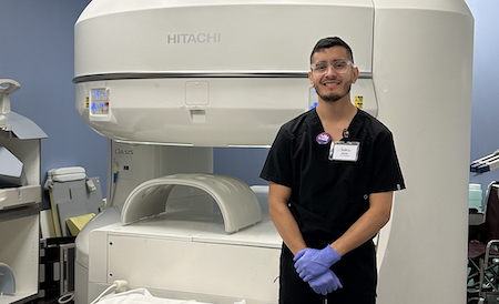 Man standing before a medical imaging machine.